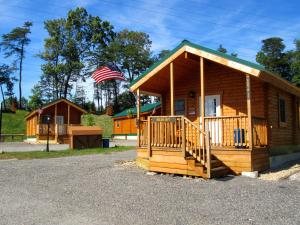a log cabin with an american flag in front of it at Cherry Hill Park in College Park