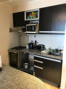 a small kitchen with a sink and a microwave at Dpto ideal in Resistencia