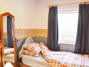 A bed or beds in a room at Old Forge Cottage 