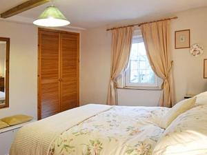 A bed or beds in a room at Old Forge Cottage 