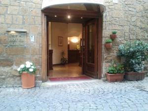 een open deur naar een gebouw met potplanten bij Hotel Valentino Centro Storico in Orvieto