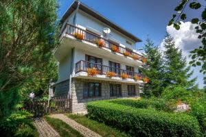 un edificio con un balcón con flores. en Szum i Las, en Szklarska Poręba