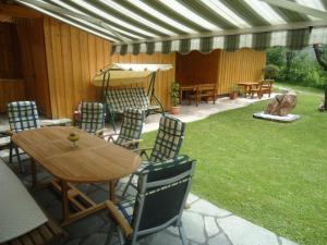 a patio with a table and chairs and an umbrella at Pension Wald in Faistenau