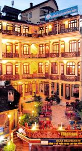 薩帕的住宿－蓮花酒店，一座黄色的大建筑,前面设有桌子