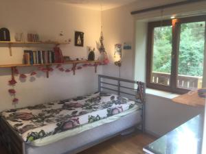 a small bed in a room with a window at Wonderful wooden house next to lake and Stockholm archipelago in Boo