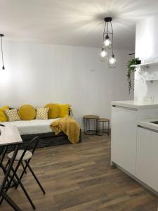コニル・デ・ラ・フロンテーラにあるConil apartamentos la Dama y el Vagabundoのリビングルーム(黄色い枕のベッド付)