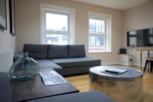 una sala de estar con un sofá y una mesa en Brick Lane Spitalfields Apartment, en Londres