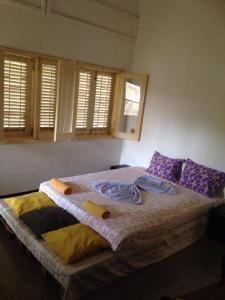 a bedroom with a large bed with purple pillows at Casa de Ferias in São Tomé