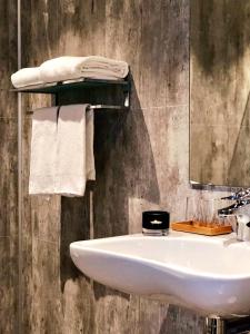 ein Badezimmer mit einem Waschbecken, einem Spiegel und Handtüchern in der Unterkunft Lyngen Experience Lodge in Nord-Lenangen