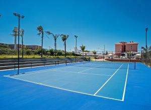 a tennis court with palm trees in the background at The Hill Hotéis Executive in São Carlos