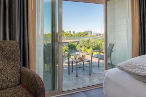 a room with a bed and a balcony with a table at Staypineapple, Hotel Rose, Downtown Portland in Portland