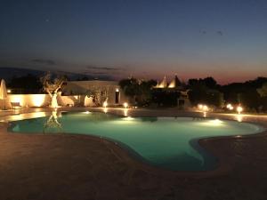 a large swimming pool at night with lights at Trulli IsAgo in Locorotondo