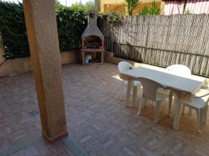 un patio con tavolo, sedie e camino di OLBIA CONAD 2 iun 3715 a Olbia
