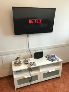 une télévision sur un mur au-dessus d'une table blanche dans l'établissement Apartamento Allegra, à Arinaga