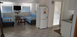 a kitchen and living room with a refrigerator and a table at Vila Una in Žuljana