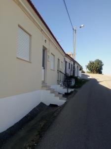 a white building with stairs next to a street at Casa Da Zu in Tomar