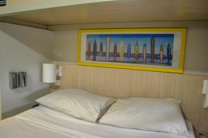 EXPRESSO R1 HOTEL في ماسيو: غرفة نوم بها سرير مع لوحة على ألواح التزلج