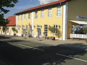 ein gelbes Gebäude an der Straßenseite in der Unterkunft Thinghuskroen in Vestervig