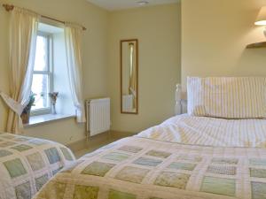 A bed or beds in a room at 2 Gill Edge Cottages 
