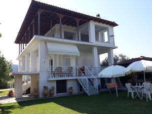 Casa blanca con balcón, mesas y sombrillas en The green garden villa by the sea!, en AgiaKampos