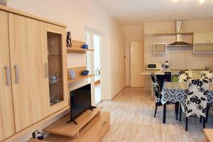 uma sala de estar com uma mesa de jantar e uma cozinha em Relax apartman em Zalakaros