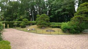un camino en un jardín con una valla en Guesthouse Taihei, en Aso