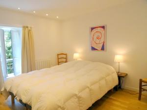 ein Schlafzimmer mit einem großen weißen Bett und einem Fenster in der Unterkunft Le Piano in Flavigny-sur-Ozerain