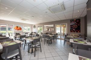 een eetkamer met tafels en stoelen in een restaurant bij ibis Sisteron in Sisteron