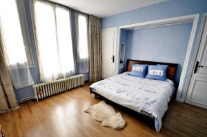 een slaapkamer met blauwe muren en een bed met een tapijt bij Chalet de Paris in Fontenay-sous-Bois