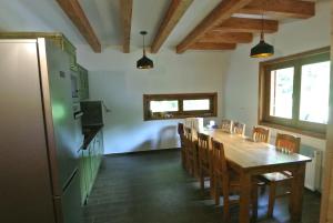 a kitchen and dining room with a table and chairs at Chalet by the river in Văliug