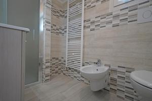 ein Bad mit einem Waschbecken, einem WC und einer Dusche in der Unterkunft Quarantotto B&B in Raffa