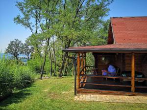 a person sitting on a porch of a log cabin at Katarina Doboj,Bušletić in Busletić