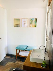 a bathroom with a sink and a table with a bench at Ferienhaus mit Sonnendeck in Sankt Wendel