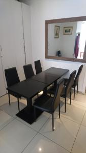 a black dining room table with chairs and a mirror at Bertha in Paris