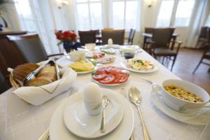 een tafel met borden en kommen met eten erop bij Leśniczówka Nibork in Nidzica