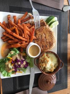 a plate of food with fries and a sandwich and dips at Luxlex in Capesterre-Belle-Eau