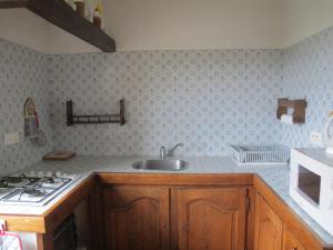 a kitchen with a sink and a stove at Cottage Poppy in Tursac +41 photos