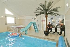 哈博尔Luksus-poolhus L21的一群人在带滑梯的游泳池里