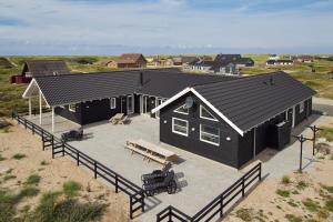 an aerial view of a black house on the beach at Luksus-poolhus L21 in Harboør