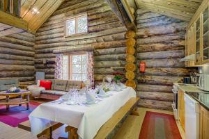 una sala da pranzo con tavolo in una baita di tronchi di VIP Rakka Villas 5 & 6 a Levi