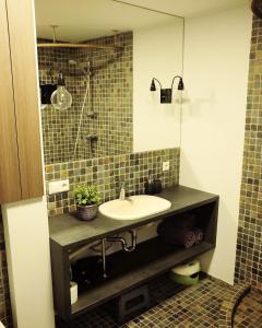 a bathroom with a sink and a mirror at Amber White apartment in Juodkrantė