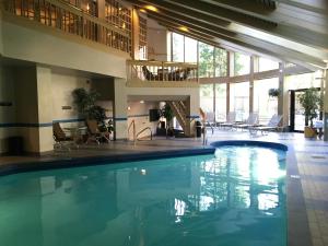 a large swimming pool in a hotel with chairs and tables at Park Plaza Beaver Creek in Beaver Creek