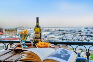 ein Buch und eine Flasche Wein und Gläser auf dem Tisch in der Unterkunft MARGHERITA's Apartment in Salerno