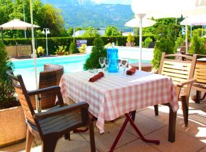 a table with a red and white checkered table cloth at The Originals City, Hôtel du Faucigny, Cluses Ouest in Scionzier