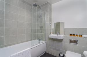 a bathroom with a bath tub and a sink at The Central Lodge in Dartford +33 photos