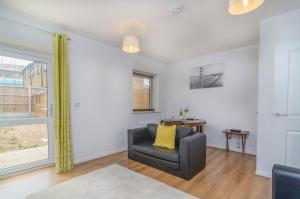 a living room with a chair and a window at The Central Lodge in Dartford