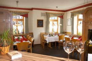 ein Esszimmer mit Tischen, Stühlen und Weingläsern in der Unterkunft Gasthof zum Goldenen Lamm in Wettelsheim
