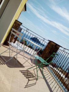 eine Terrasse mit einem Stuhl und einem Geländer in der Unterkunft Verde Mare in Alassio