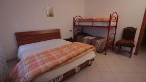 sypialnia z 2 łóżkami piętrowymi i krzesłem w obiekcie Agriturismo Bellavista w mieście Arsita