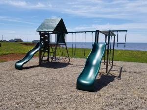a playground with two slides and a play structure at Blue Spruces Cottages in Hampton 